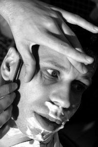 man shaving black and white